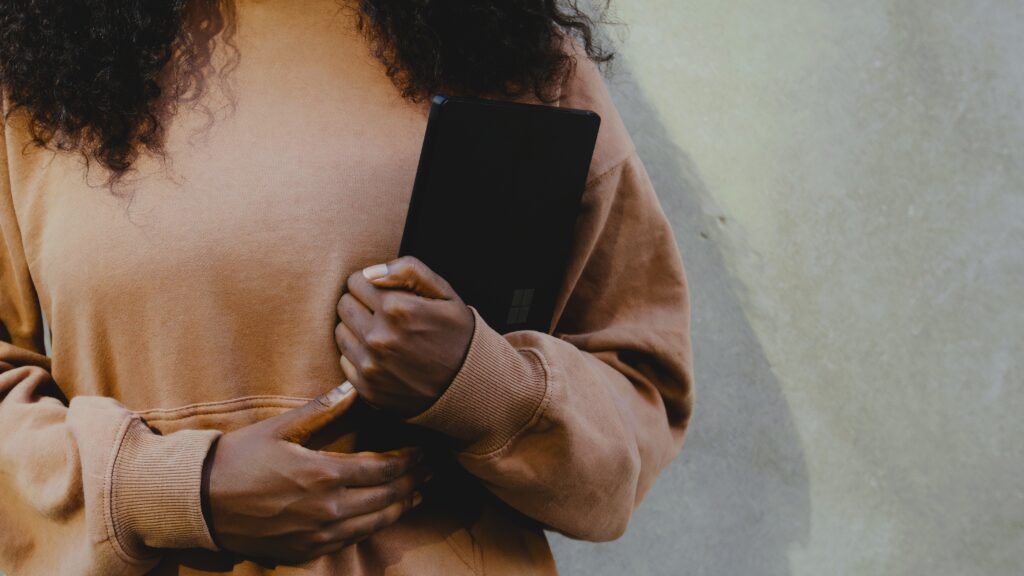 Image of student holding a Surface tablet. Student is decentered and tablet is centered.