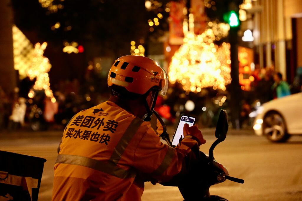 A delivery person looks at mobile phone